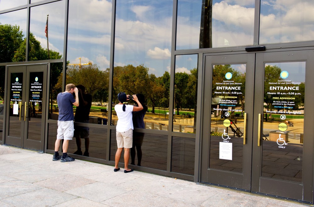 Tourists peer into the closed Smithsonian Air and Space Museum October 5, 2013 in Washington, DC.