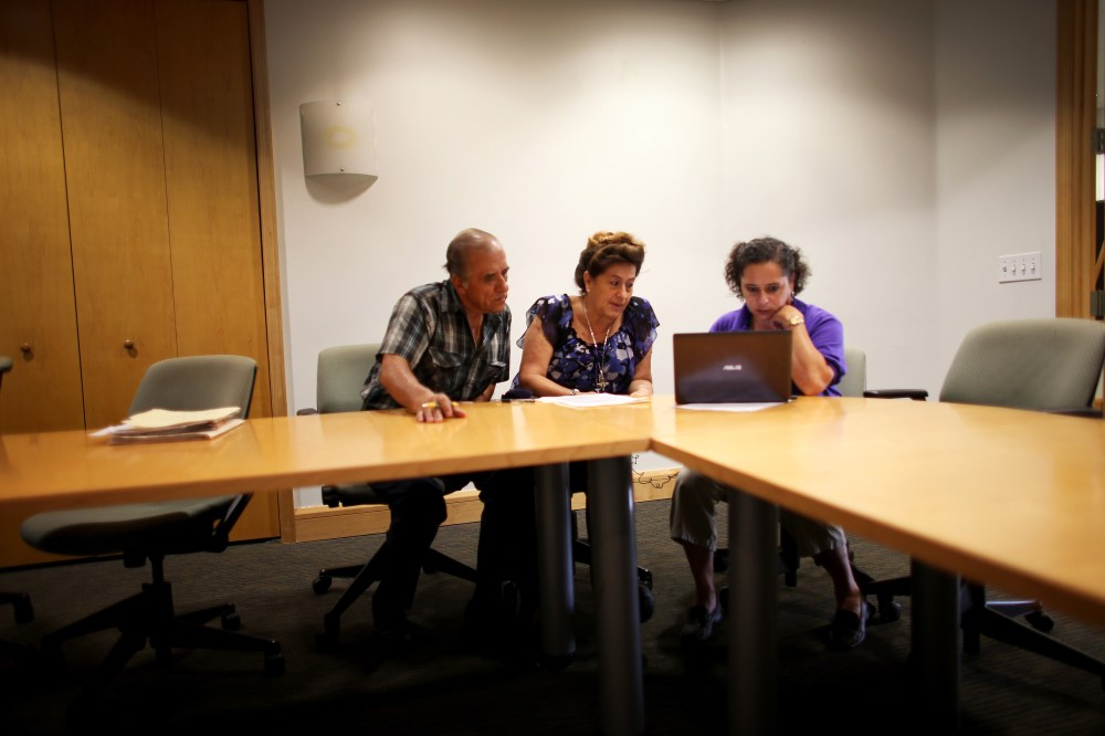 Affordable Care Act navigator Nini Hadwen helps Jorge Hernandez and Marta Aguirre as they shop for health insurance in Miami, Florida, October 8, 2013.