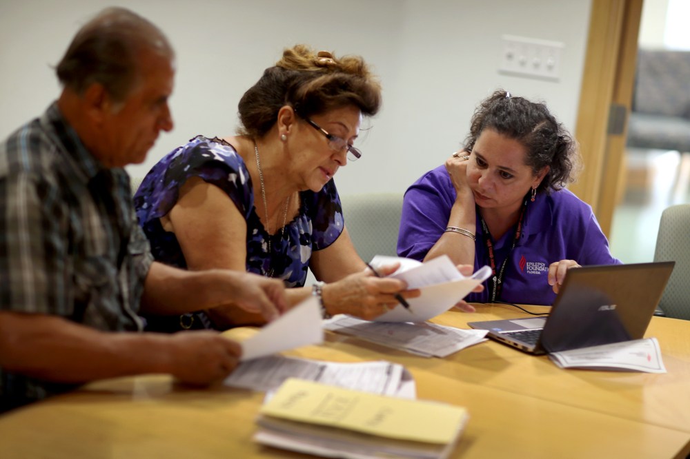 Affordable Care Act navigator Nini Hadwen speaks with Jorge Hernandez and Marta Aguirre as they shop for health insurance.