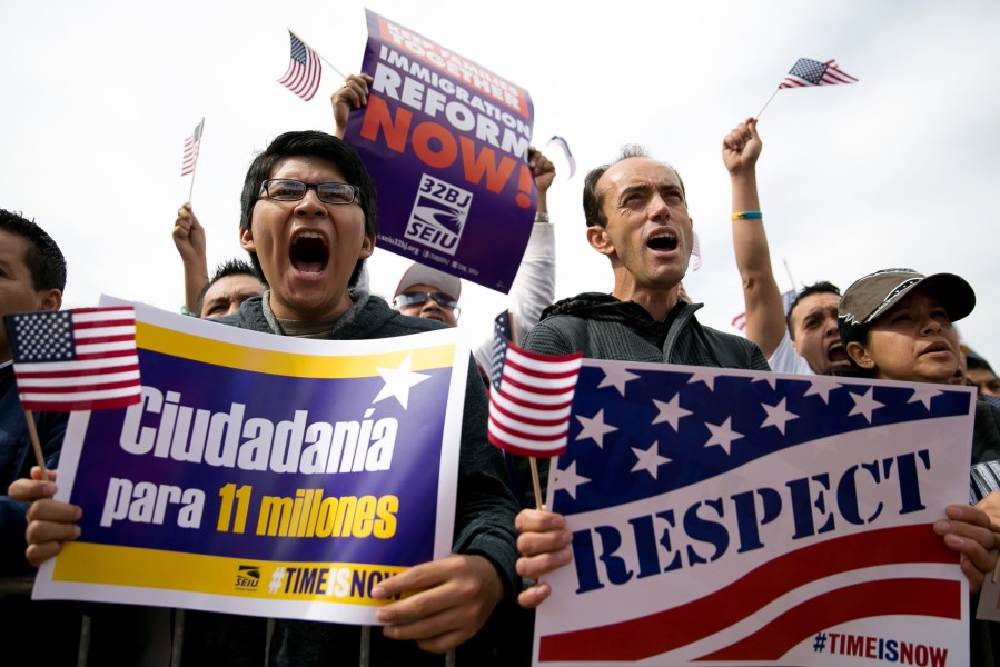 Hernan Morales (L), a student at American University, and Juan Martinez (R), cheer during a rally in support of immigration reform, in Washington, on Oct. 8, 2013.