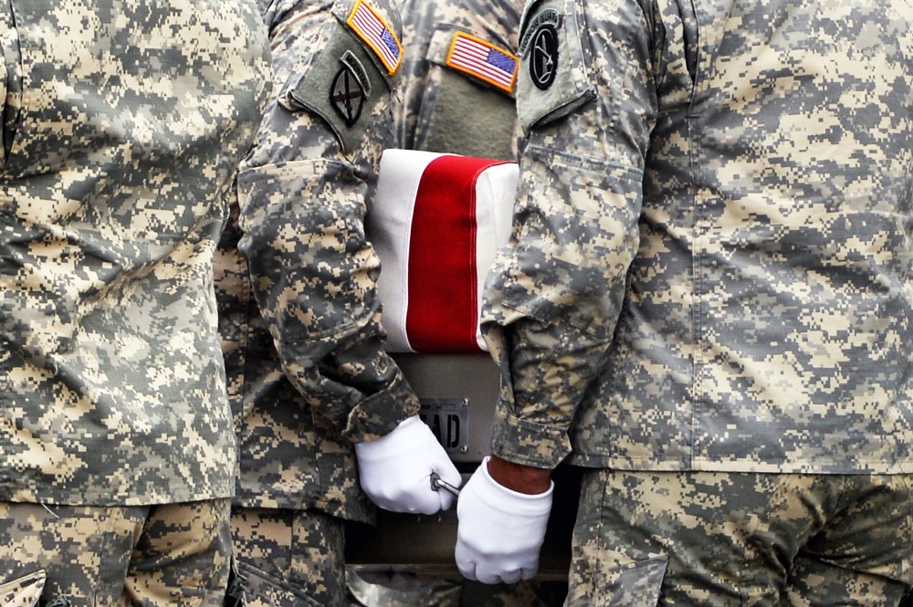 U.S. Army soldiers carry the flag-draped transfer case containing the remains of U.S. Army Pfc. Cody J. Patterson during a dignified transfer at Dover Air Force Base on October 9, 2013 in Dover, Delaware.