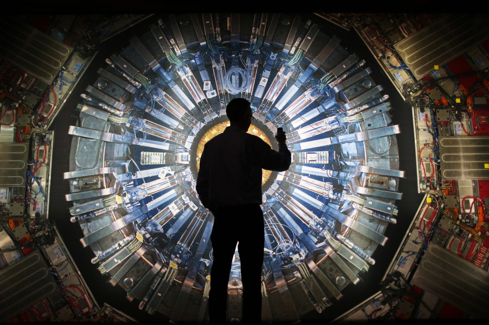A visitor takes a photograph of an image of the Large Hadron Collider (LHC) at the Science Museum's 'Collider' exhibition on November 12, 2013 in London, England.