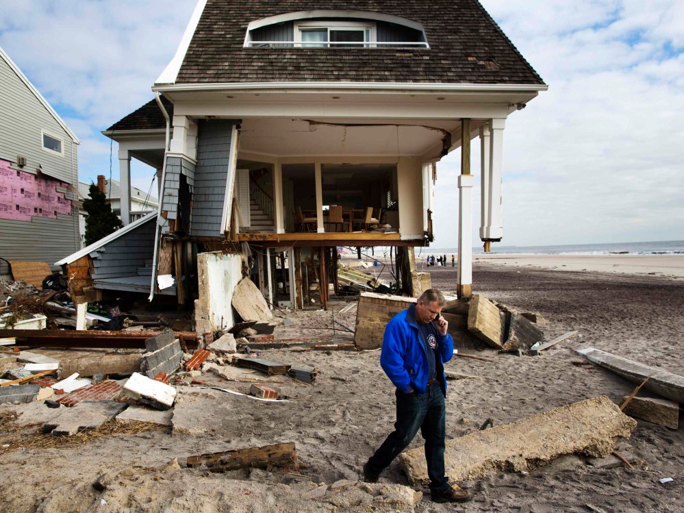 Homeowner Rob Ostrander talks on the phone in front of his Hurricane Sandy damaged home in the Brooklyn borough region of Belle Harbor in New York November 14, 2012.  (Photo by Lucas Jackson/Reuters)