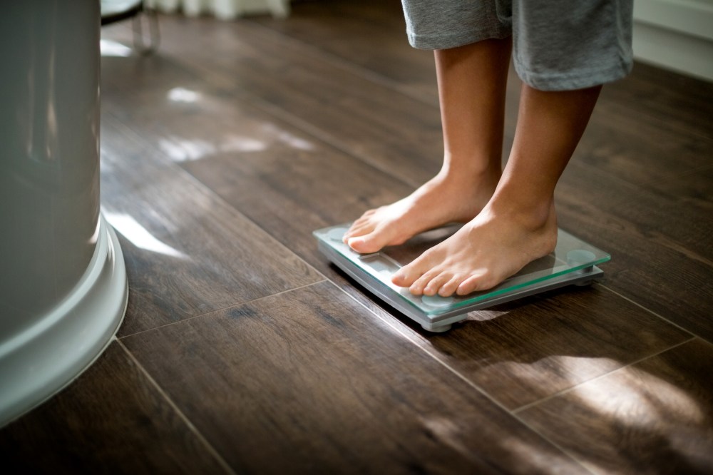 Image: Boy checking his weight on weight scale
