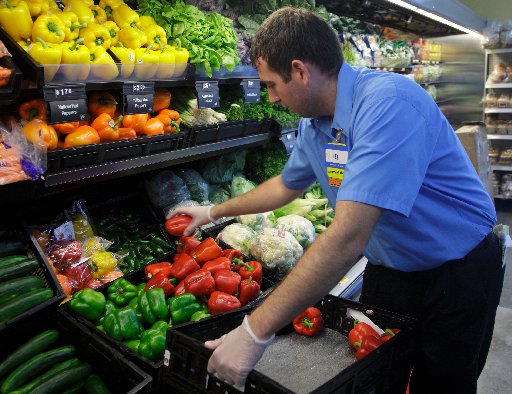 A worker stocks a new Walmart Express store in Chicago July 26, 2011. Chicago low-wage workers such as this one can look forward to additional protections against wage theft under a new city ordinance.(Photo by John Gres/REUTERS)