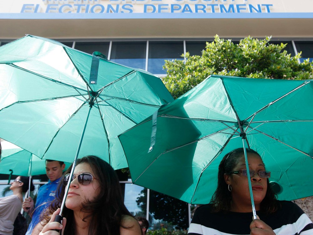 Yaine Noguera (L) and Sheron Reid wait in line to obtain and deposit their absentee ballots at the Miami-Dade County Elections Department Headquarters on the final day before Election Day, in Doral, Florida November 5, 2012. (Photo by  REUTERS/Andrew...