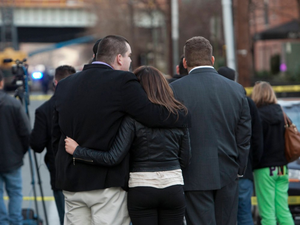 Residents look on where police cordoned off a crime scene related to the shootings at Sandy Hook Elementary School, in Hoboken, New Jersey, December 14, 2012. In Hoboken, New Jersey, police cordoned off a block in connection with the Connecticut...