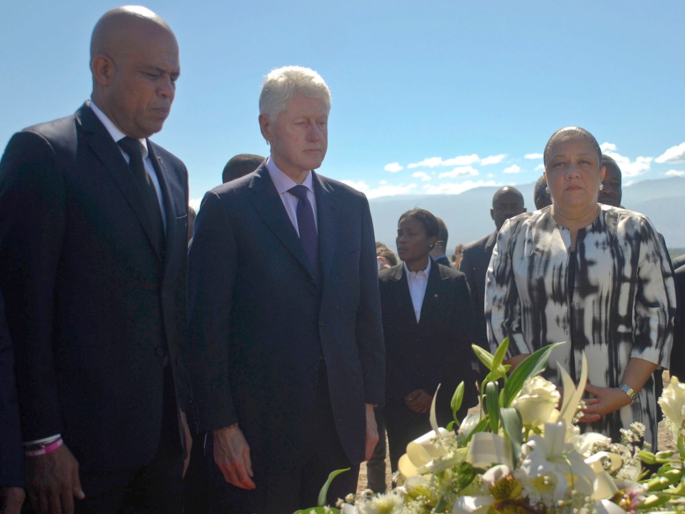 Haiti's President Michel Martelly (L), former U.S. president Bill Clinton (2nd L) and Haiti's First Lady Sophia Martelly (2nd R) visit a memorial service remembering the lives lost in the January 2010 earthquake at the mass burial site at Morne St....