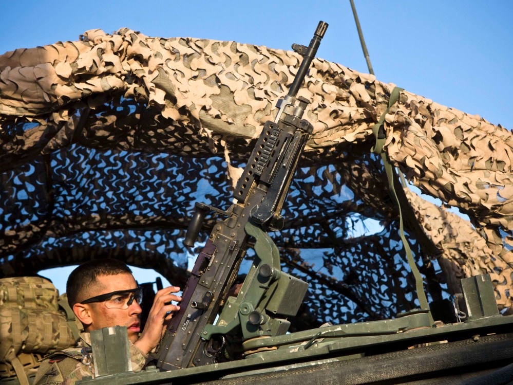 A soldier with 1st Battalion, 36th Infantry Regiment, loads a gun before a mission outside command outpost Hutal, Maywand District, Kandahar Province, Afghanistan, January 17, 2013. (Photo by Andrew Burton/Reuters)