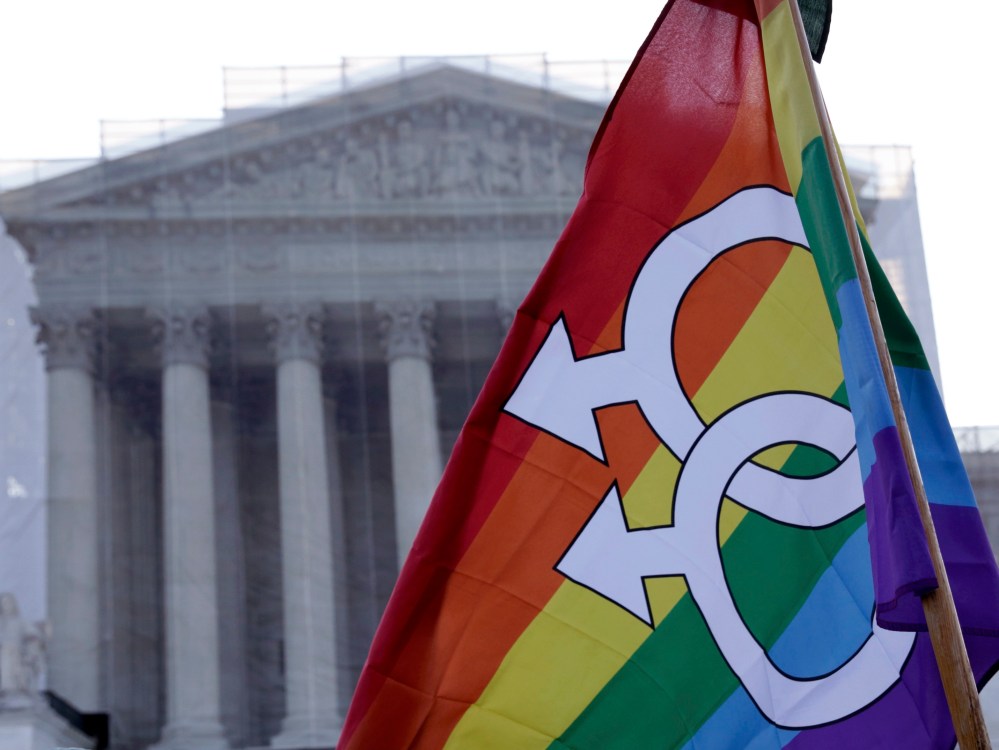 A protester raises a flag outside of the U.S. Supreme Court in Washington, March 26, 2013. (Photo by  Joshua Roberts/Reuters)