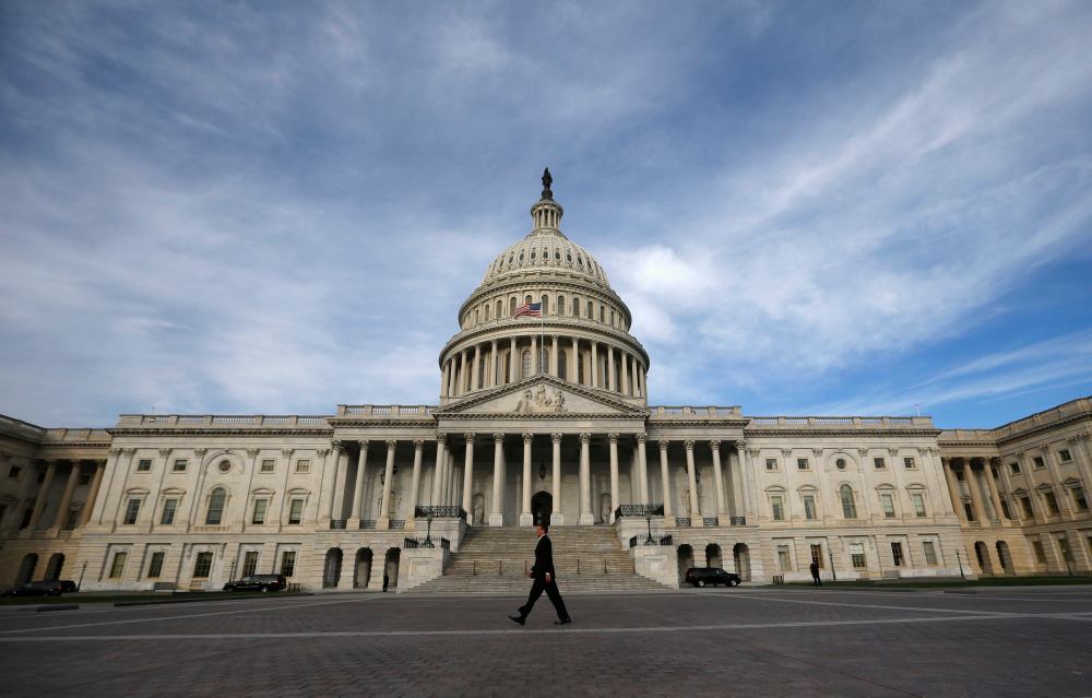 A lone worker passes by the U.S. Capitol building in Washington, October 8, 2013.