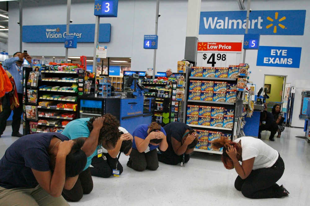 Walmart employees practice the drop, cover, and hold on technique during the "Great ShakeOut" " earthquake drill at Walmart in Torrance, California October 17, 2013.
