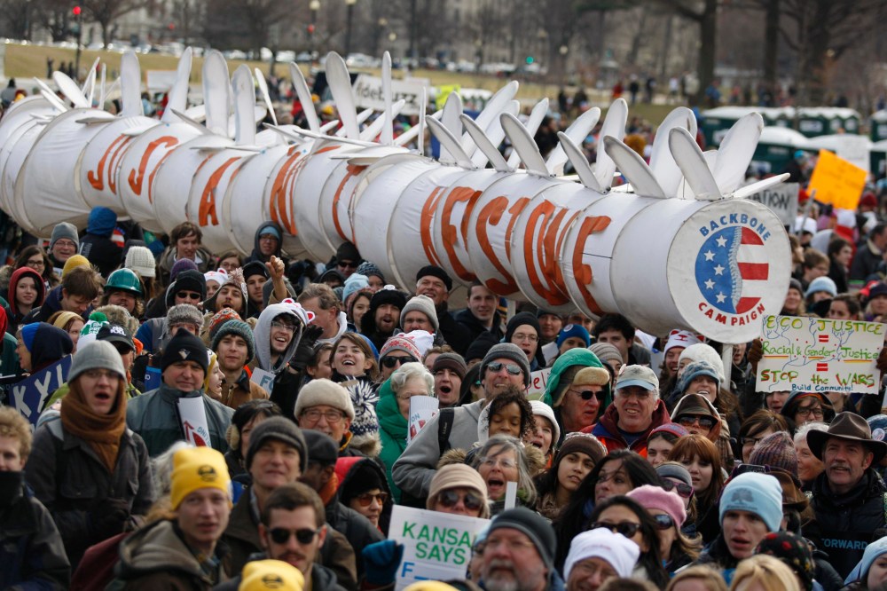Demonstrators carry a replica of a pipeline during a march against the Keystone XL pipeline in Washington, in this February 17, 2013 file photo.