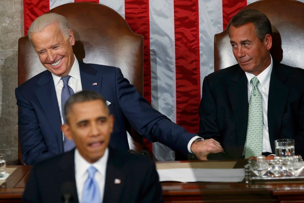U.S. Vice President Joe Biden (L) grabs the arm of House Speaker John Boehner (R-OH)  as President Barack Obama delivers his State of the Union address in front of the U.S. Congress, on Capitol Hill in Washington, Jan. 28, 2014.