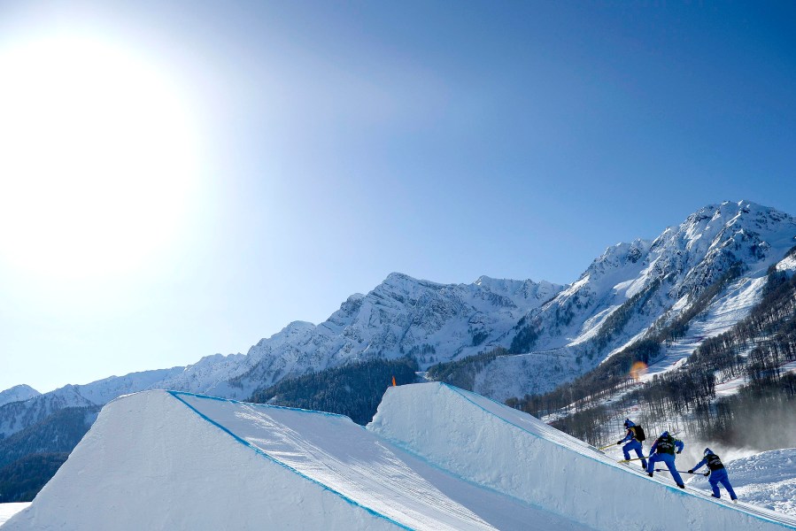 Officials prepare a jump on the slopestyle snowboard course during a break in practice for the 2014 Sochi Winter Olympics in Rosa Khutor Feb. 4, 2014.