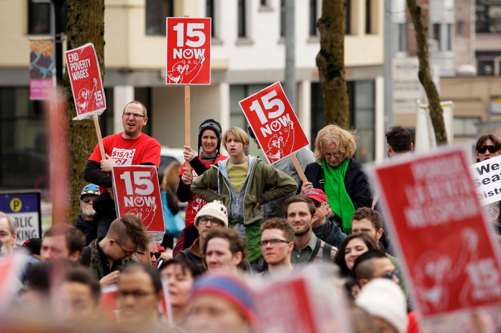 People rally in support of a $15 minimum wage at Seattle Central Community College in Seattle, Washington March 15, 2014.