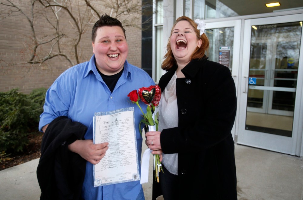 Newly married Sarah Brown (L)  and Dolly Vanfossan hold their marriage license outside after being married at the Oakland County Courthouse in Pontiac, Michigan, March 22, 2014.