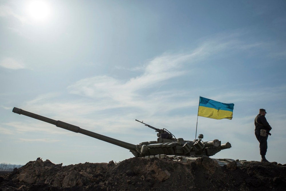 A soldier stands guard near a tank position close to the Russian border near the Ukranian city of Kharkiv, March 24, 2014.