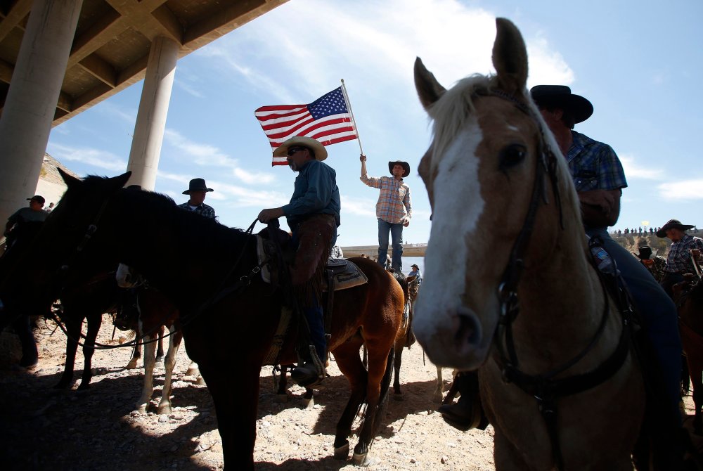 Image: A protester waves the U.S. flag near the Bureau of Land Management's base camp where seized cattle, that belonged to rancher Cliven Bundy, are being held at near Bunkerville