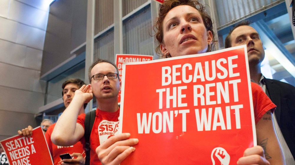 Labor activists Ginger Jentzen and Jeremy Thornes listen during a Seattle City Council meeting in which the council voted on raising the minimum wage to $15 per hour in Seattle, Washington.