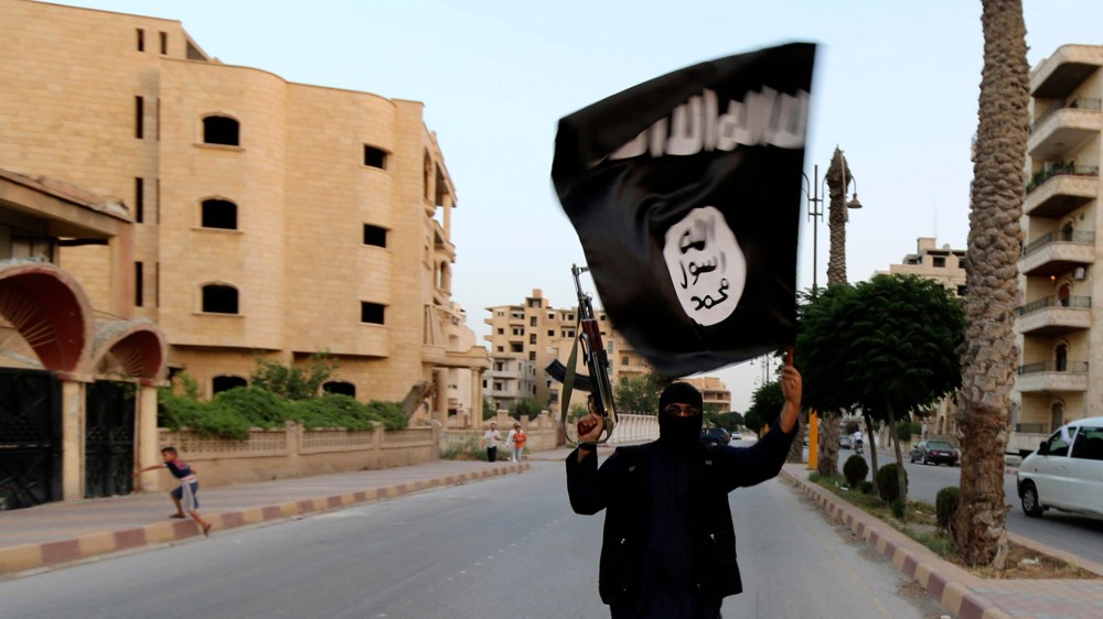 A member loyal to the Islamic State in Iraq and the Levant (ISIL) waves an ISIL flag in Raqqa June 29, 2014.