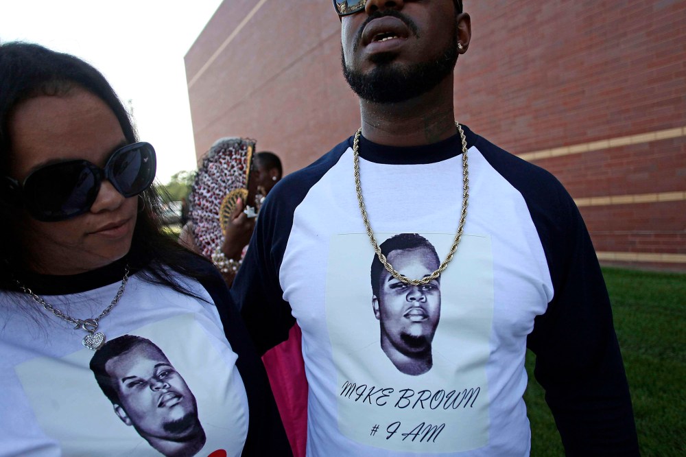 People wearing T-shirts with pictures of Michael Brown wait in line to attend his funeral at Friendly Temple Missionary Baptist Church in St. Louis, Missouri