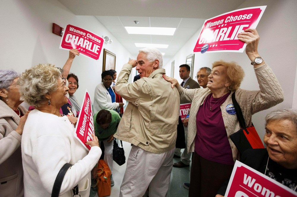 Former Florida Governor and Democratic gubernatorial candidate Charlie Crist (C) heads out of the Mid-County Senior Center, during a four-city bus campaign tour in Lake Worth, Fla. on Nov. 3, 2014.