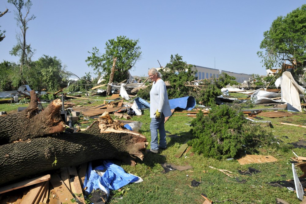 Darla Titus looks through debris in her backyard the morning after a tornado in Oklahoma City, Okla., May 7, 2015. (Photo by Nick Oxford/Reuters)
