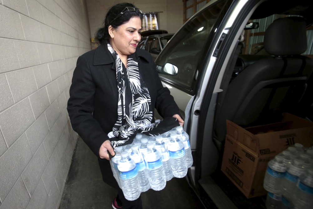 Food Pantry volunteer Asia loads bottled water into a vehicle at the Food Bank of Eastern Michigan's warehouse that will be distributed to the public, after elevated lead levels were found in the city's water, in Flint, Michigan, December 16, 2015.