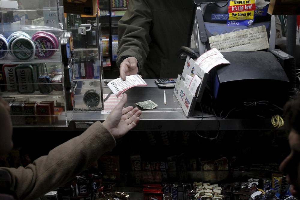 A customer purchases a Powerball lottery tickets at a news stand on Jan. 13, 2016. (Photo by Brendan McDermid/Reuters)