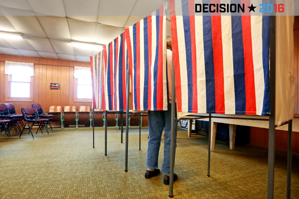 A voter casts a ballot behind a curtain at Smelser Town Hall, Nov. 8, 2016, in Georgetown, Wis. (Photo by Nicki Kohl/Telegraph Herald/AP)