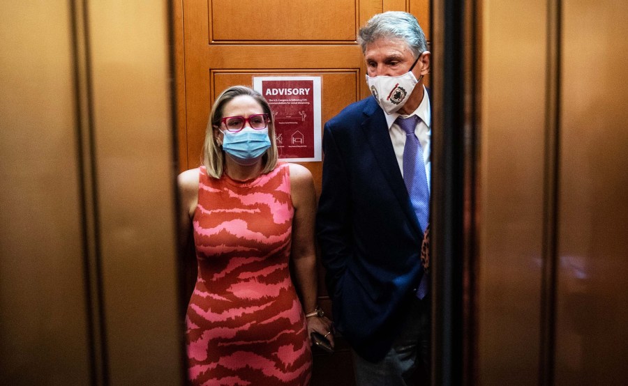 Sen. Kyrsten Sinema and Sen. Joe Manchin catch and an elevator to go to the Senate Chamber to vote, after meeting in Sen. Manchin's hideaway for half an hour in the U.S. Capitol on September 30, 2021 in Washington, DC.