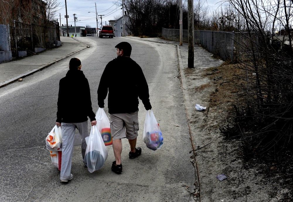 WOONSOCKET, RI - MARCH 01: (L) Amanda Aubin and Cody Allison carry $70.00 worth of groceries to their apartment about one-half mile away. They had money left over on their food stamp card but this amount of food was all that they could carry on foot. Some of the items purchased were for their 4 year-old daughter who was having a birthday party the next day. Many families and individuals in Woonsocket, Rhode Island are needy and take part in the SNAP (food stamps) program.