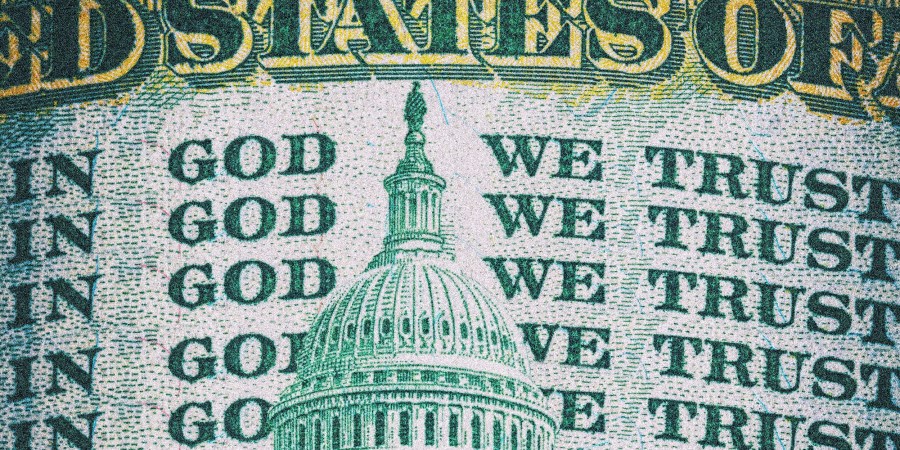 Photo Illustration: A dollar bill repeats the motto 