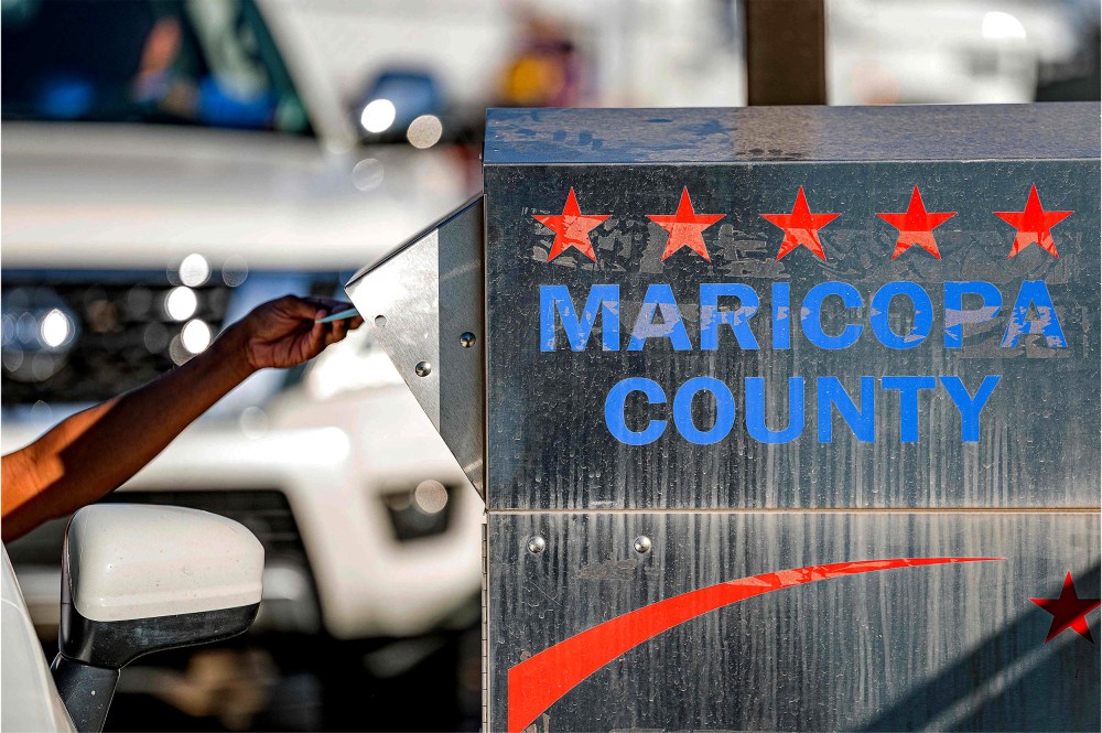Image: A voter drops their ballot in a dropbox in the midterm election at the Maricopa County Tabulation and Election Center.