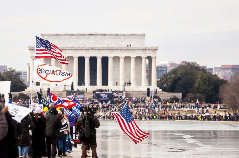 A demonstrators waves an American and anti-socialism flag during the Defeat the Mandates rally in Washington, D.C.