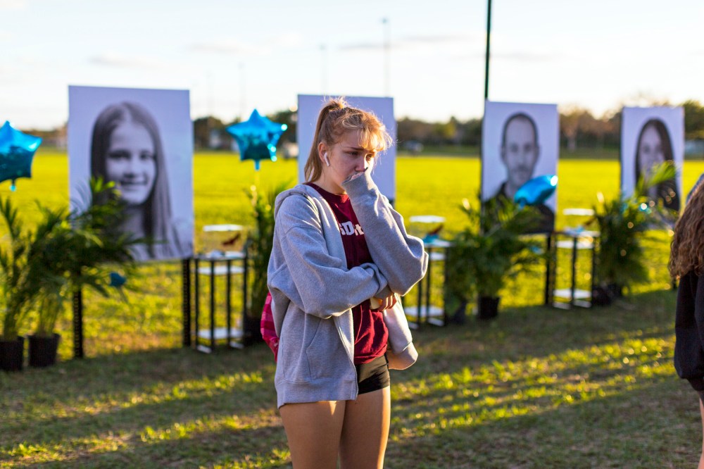 A woman visits a memorial for the victims of the Marjory Stoneman Douglas High School mass shooting in Parkland, Fla.