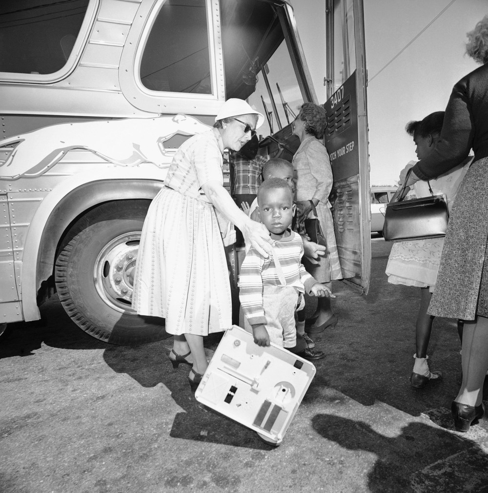 Two unidentified women, residents of Hyannis, Mass., help some of the nine children of Lela Mae Williams off the bus, June 8, 1962.
