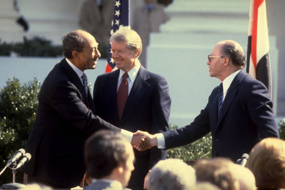 Israeli Prime Minister Menahem Begin, right, and Egyptian President Anwar Sadat, left, shaking hands after signing the Israeli-Egyptian peace treaty under the watch of President Jimmy Carter on the White House lawn on March 26, 1979.