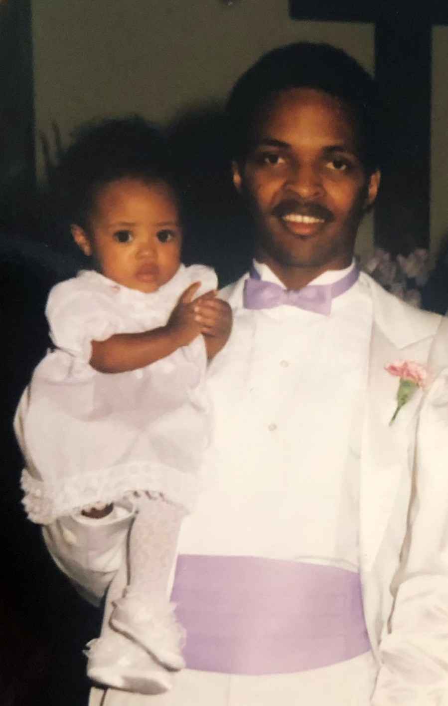 Author Amira Barger is held by her father as an infant in the 1980s.