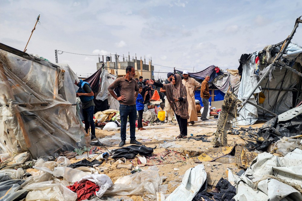 Palestinians examine the destroyed makeshift tents.