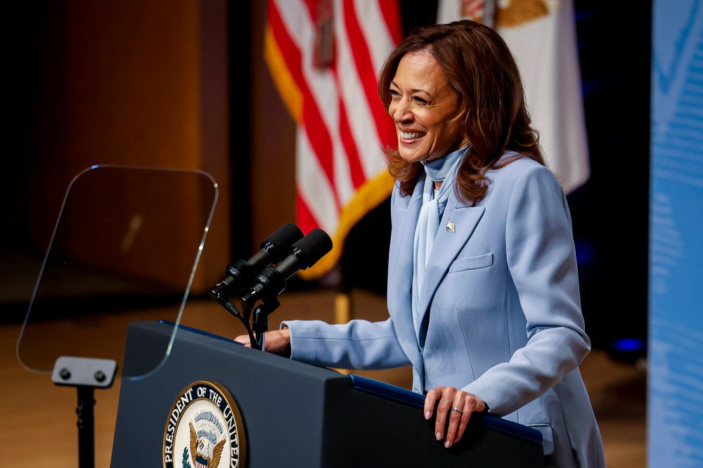 Kamala Harris smiles while standing behind a podium