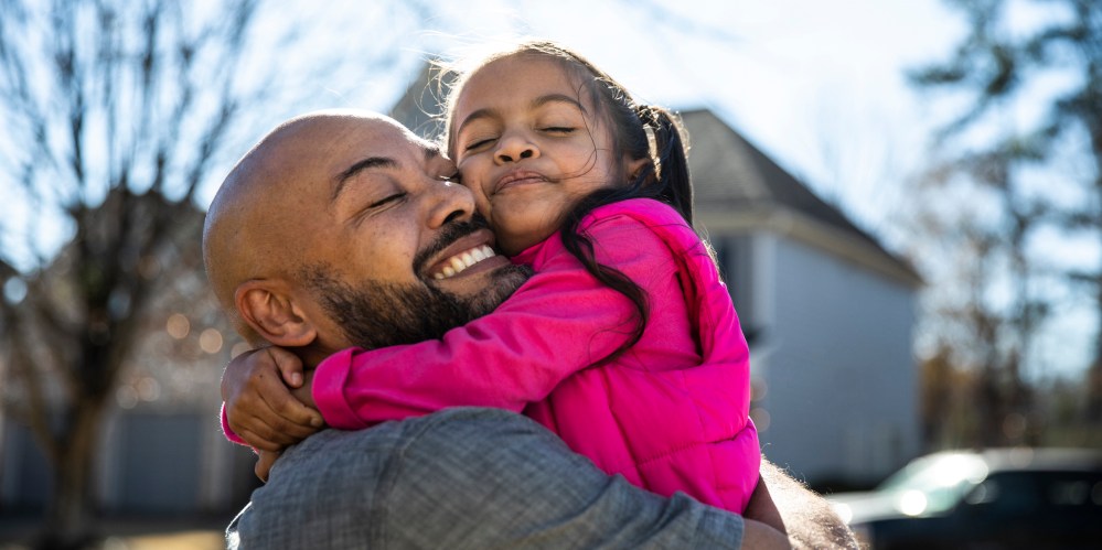 Father holding young daughter outdoors