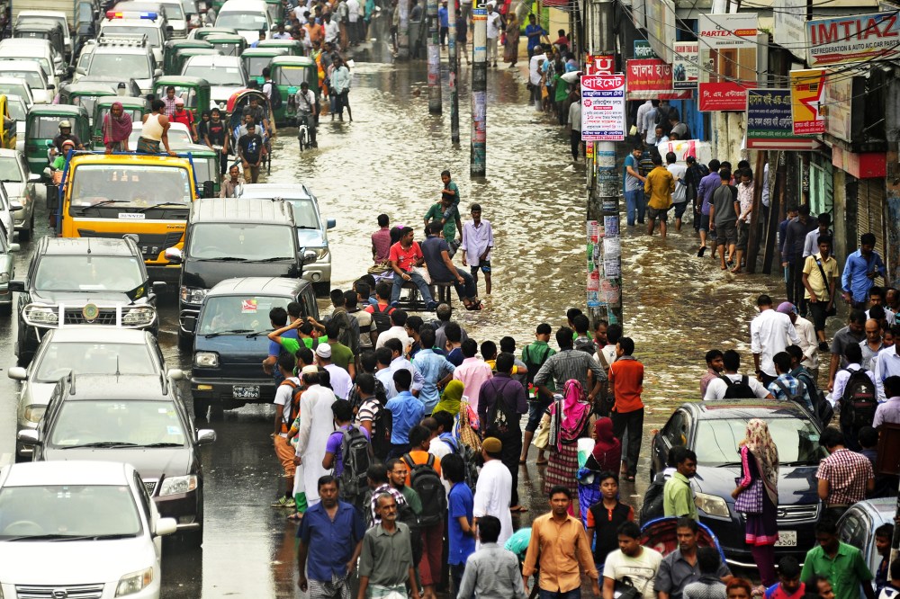 Citizens of Dhaka, Bangladesh are caught in heavy downpour at Kazi Nazrul Islam Avenue on Sept. 1st, 2015. (Photo by Firoz Ahmed/Demotix/Corbis)