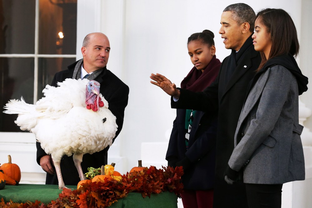 U.S. President Barack Obama pardons "Popcorn" with his daughters Sasha and Malia at the White House, Nov. 27, 2013.