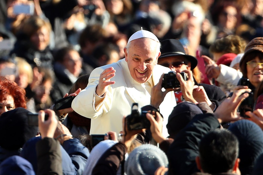 Pope Francis waves to the faithful as he arrives for his weekly audience in Vatican City, Dec. 4, 2013.