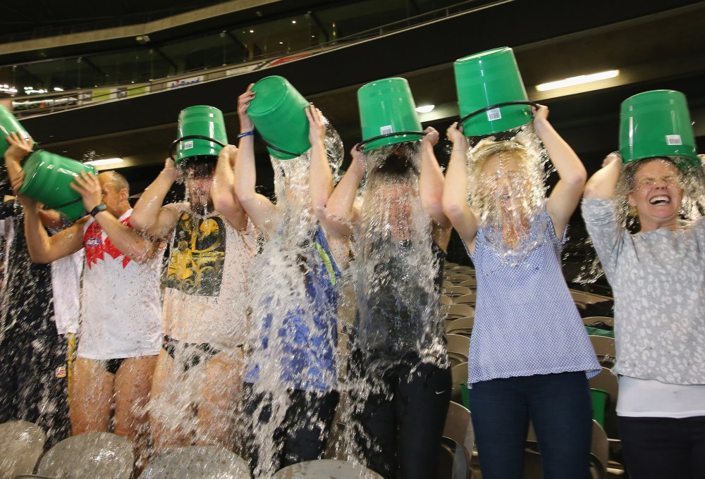 Participants tip buckets of ice water over their heads as they take part in the World Record Ice Bucket Challenge at Etihad Stadium on August 22, 2014 in Melbourne, Australia.