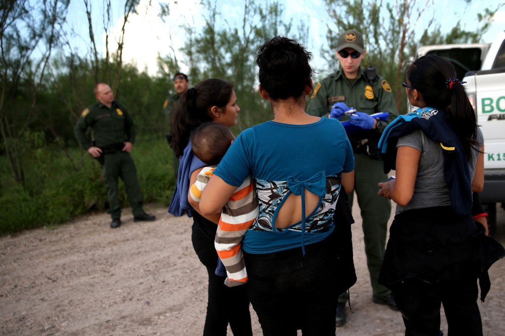 Families of Central American immigrants turn themselves in to US Border Patrol agents after crossing the Rio Grande River from Mexico on Sep. 8, 2014 to McAllen, Texas. (Photo by John Moore/Getty)