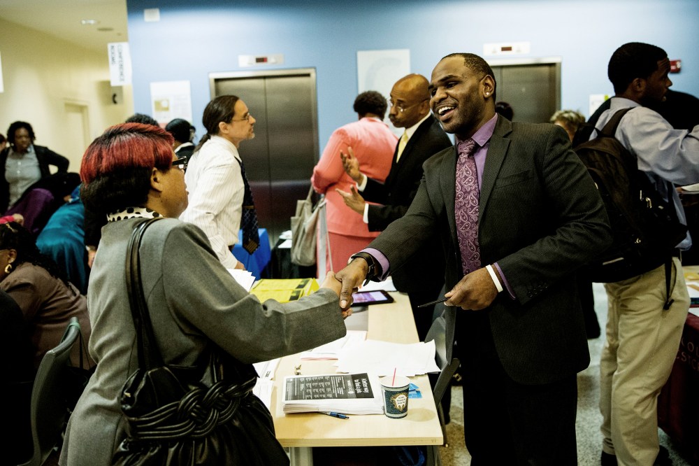 Carl Gilbert (R), of Upper Manhattan Work Force 1 Career Center, meets with a woman looking for a job at a jobs fair at the Bronx Public Library on Sept. 17, 2014 in the Bronx Borough of New York, N.Y. (Photo by Andrew Burton/Getty)