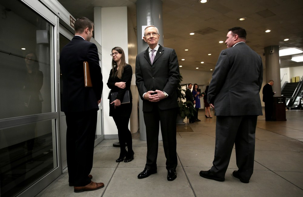 U.S. Senate Majority Leader Sen. Harry Reid (D-NV) (C) waits for the Senate subway after a vote December 17, 2013 on Capitol Hill in Washington, DC.